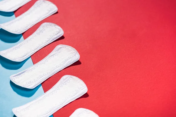 High angle view of row of daily pads on blue and red — Stock Photo