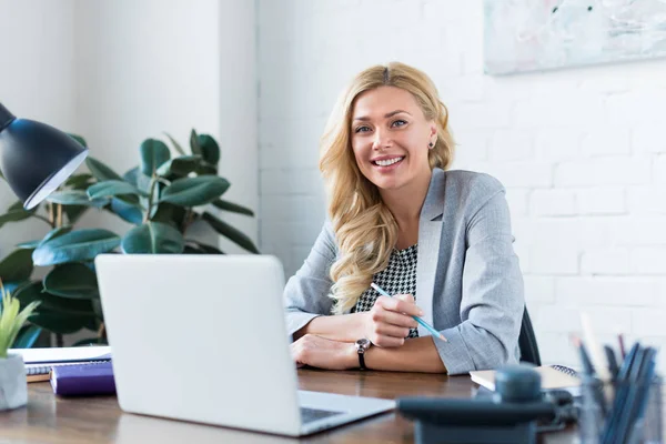 Smiling businesswoman looking at camera in office — Stock Photo