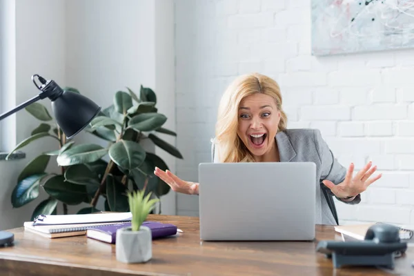 Donna d'affari sorpresa guardando il computer portatile in ufficio — Foto stock