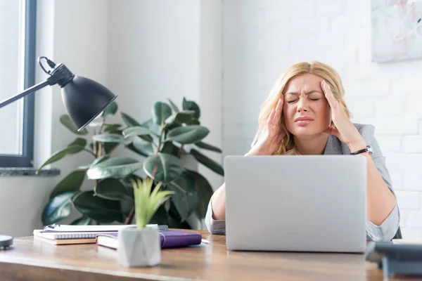 Businesswoman having headache and touching head with hands — Stock Photo