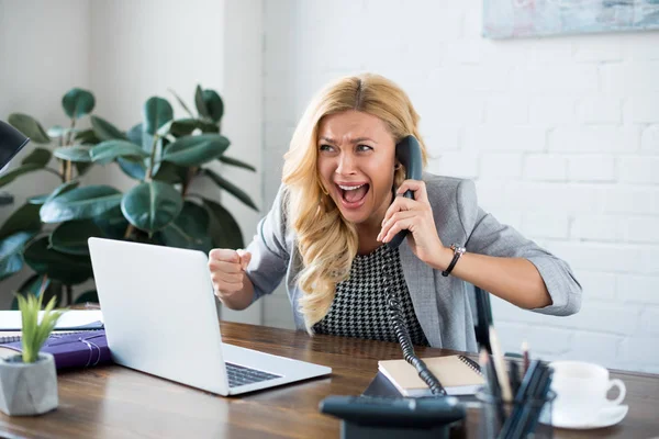 Mujer de negocios emocionada hablando por teléfono en la oficina y mostrando sí gesto — Stock Photo