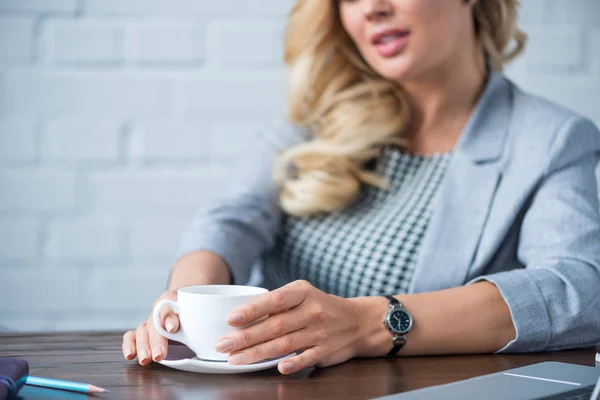 Imagen recortada de la mujer de negocios sosteniendo la taza de café en la oficina - foto de stock