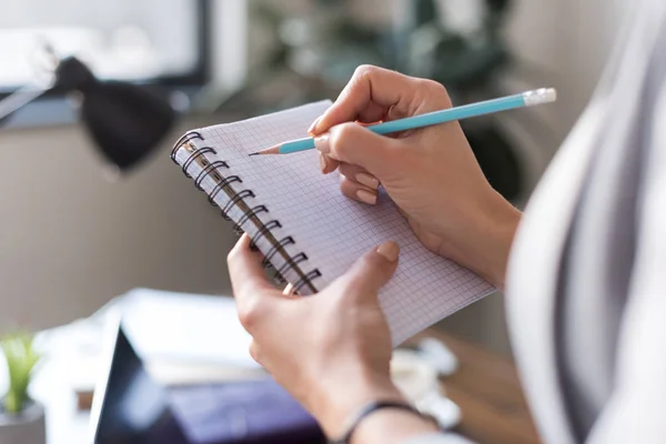 Imagen recortada de la mujer de negocios escribiendo algo en el cuaderno - foto de stock