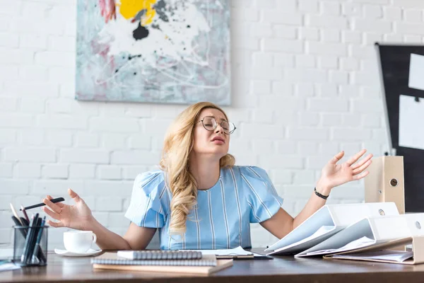 Donna d'affari esausta gesticolare con gli occhi chiusi in ufficio — Foto stock