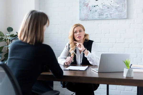 Rear view of businesswoman talking with coworker in office — Stock Photo