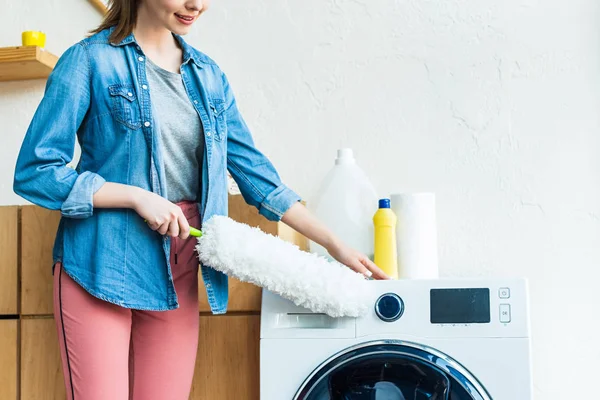 Tiro recortado de sorrir jovem mulher limpeza máquina de lavar roupa — Fotografia de Stock