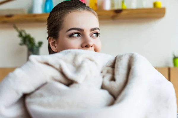 Beautiful young woman looking away while holding clean towel — Stock Photo