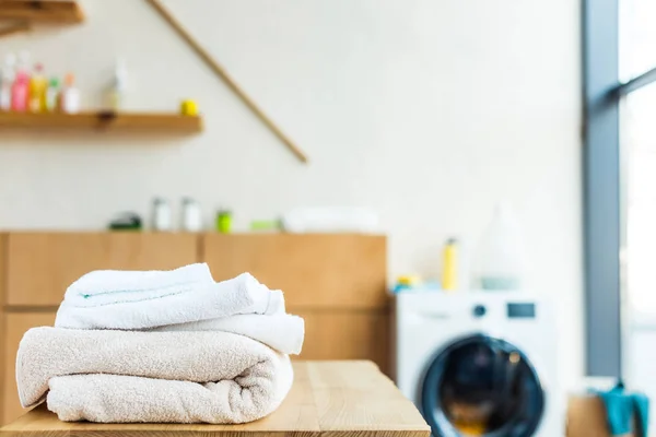 Nahaufnahme von gestapelten sauberen Handtüchern auf dem Holztisch zu Hause — Stockfoto