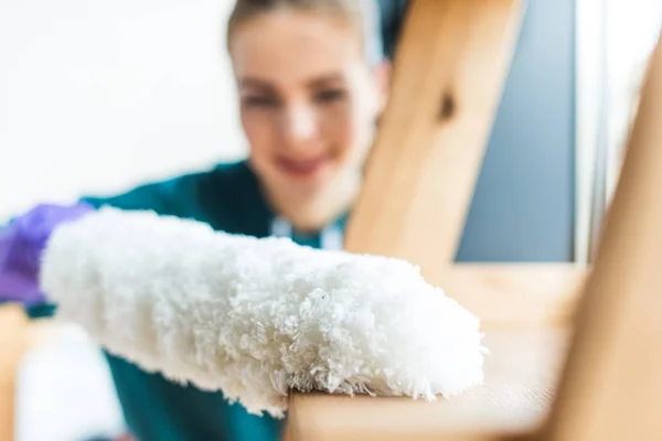 Close-up view of young woman with duster cleaning home — Stock Photo