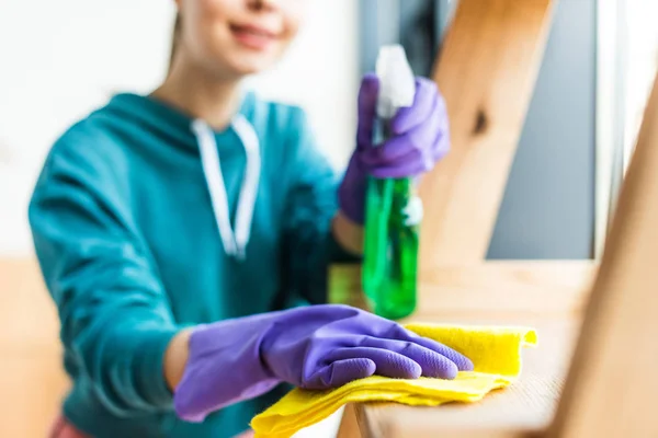 Selective focus of woman in rubber gloves cleaning home — Stock Photo