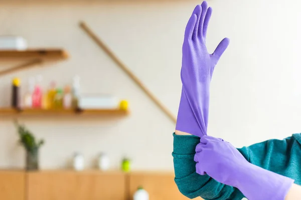 Colpo ritagliato di giovane donna che indossa guanti di gomma durante la pulizia della casa — Foto stock