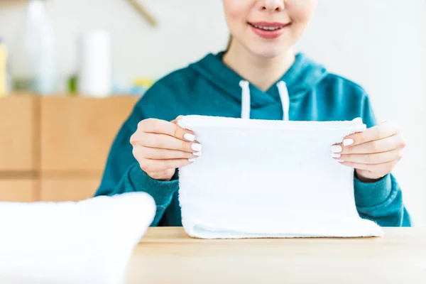 Ritagliato colpo di sorridente giovane donna in possesso di asciugamano bianco — Foto stock