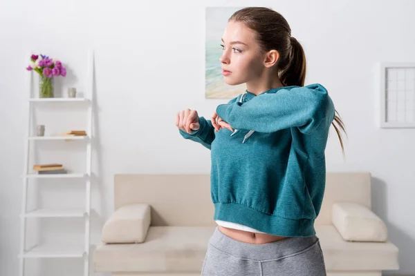 Beautiful girl exercising in sportswear at home — Stock Photo