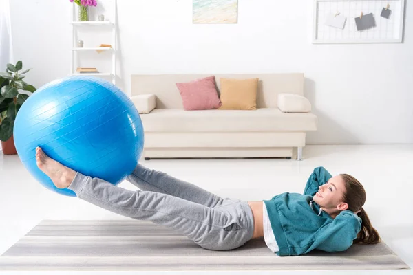 Visão lateral da menina fazendo exercício de fitness em casa — Fotografia de Stock