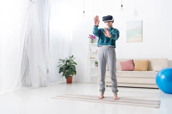 Girl touching something with virtual reality headset at home — Stock Photo