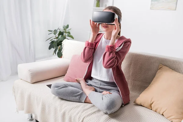 Girl sitting in lotus position with virtual reality headset at home — Stock Photo