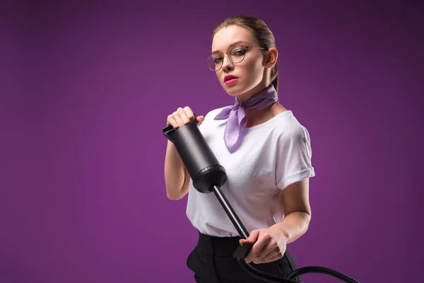 Girl holding pump and looking at camera isolated on purple — Stock Photo