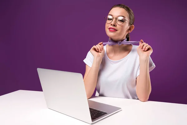 Chica sosteniendo el pañuelo y mirando a la cámara aislada en púrpura - foto de stock