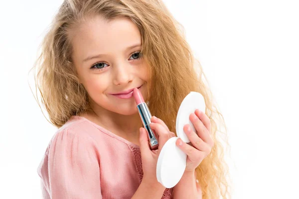 Retrato de un niño sonriente maquillándose con lápiz labial rosa aislado en blanco - foto de stock