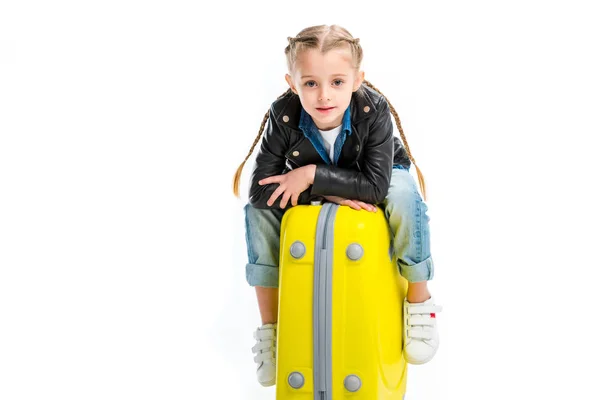 View of kid with pigtails sitting on yellow wheel suitcase isolated on white — Stock Photo