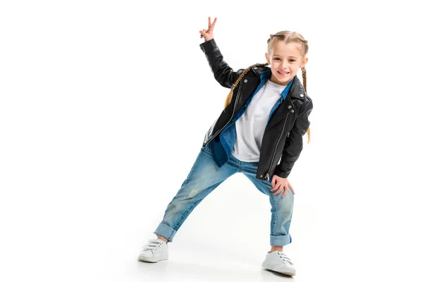 Enfant élégant et souriant portant une veste en cuir noir et signe de paix gestuel isolé sur blanc — Photo de stock