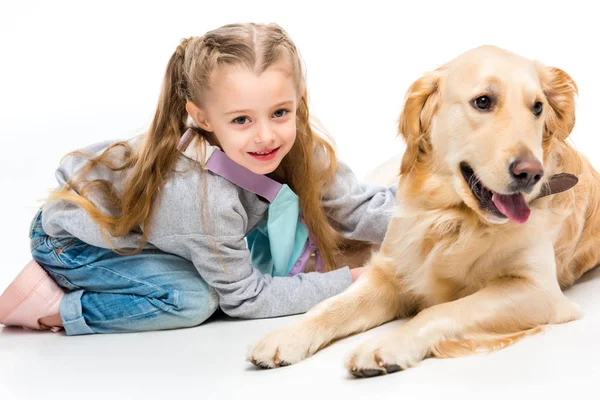 Vista de cerca de niño sonriente con perro beige acostado aislado en blanco - foto de stock