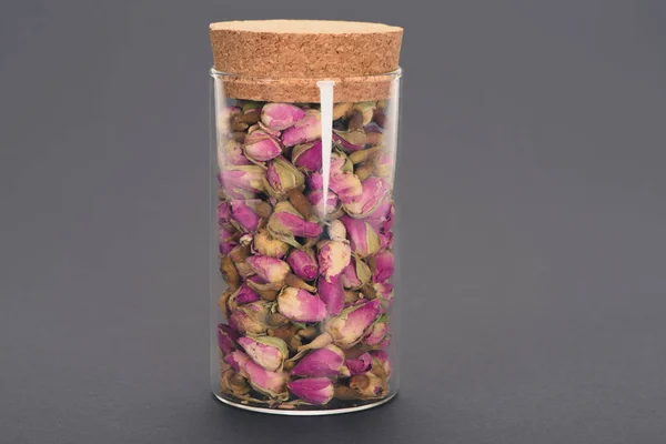 Close-up vista de belos botões de rosa seca em frasco de vidro isolado em cinza — Fotografia de Stock