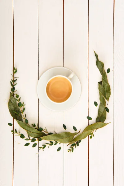 Vista superior de la corona floral y la taza de café en la mesa de madera - foto de stock