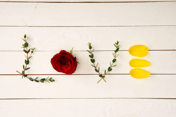 Vue du dessus de mot amour faite à partir d'éléments floraux sur la surface en bois — Photo de stock