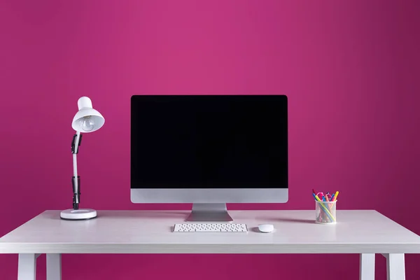 Computadora de escritorio con pantalla en blanco, teclado, ratón de computadora y suministros de oficina en la mesa - foto de stock