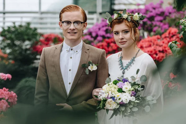 Красивая элегантная молодая рыжая свадебная пара улыбается в камеру — стоковое фото