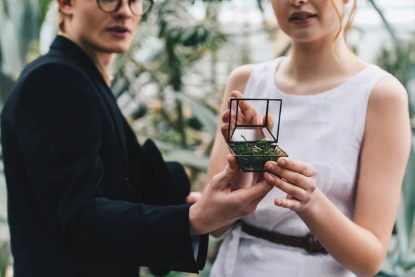 Tiro recortado de jovem casal elegante segurando caixa de jóias com anel de noivado — Fotografia de Stock