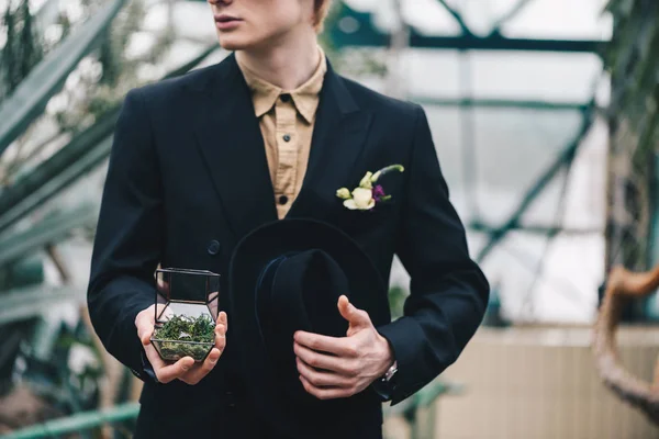 Cropped shot of stylish young groom holding jewelry box with wedding ring — Stock Photo
