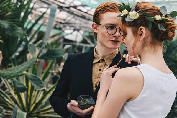 Beau jeune couple de mariage aux cheveux roux avec bague de fiançailles dans le jardin botanique — Photo de stock