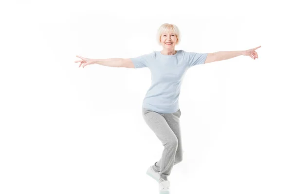 Smiling senior sportswoman standing with wide arms isolated on white — Stock Photo