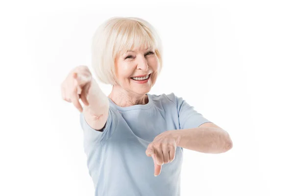 Smiling senior woman ponting by fingers isolated on white — Stock Photo