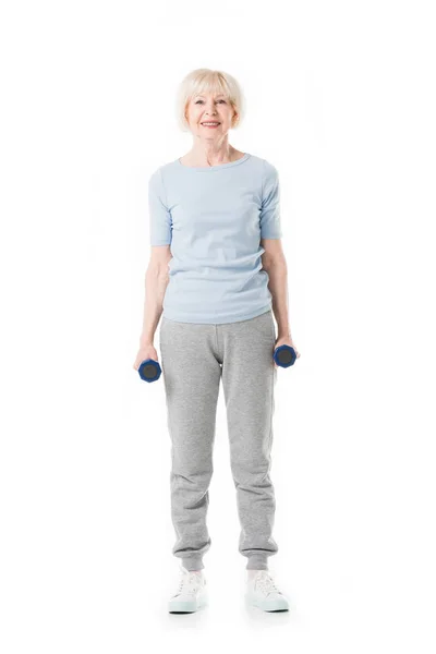 Senior sportswoman standing with dumbbells in hands isolated on white — Stock Photo