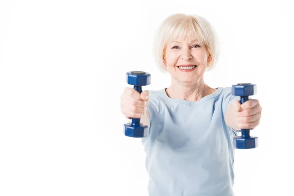Sportiva anziana sorridente con manubri in mani isolate su bianco — Foto stock