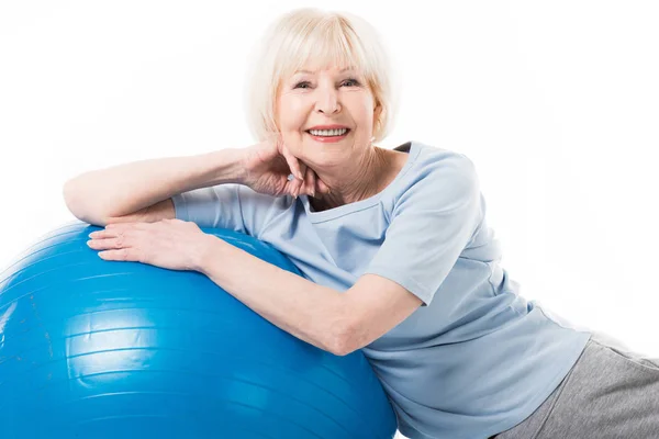 Портрет усміхненої старшої спортсменки з фітнес-кулькою ізольовано на білому — стокове фото