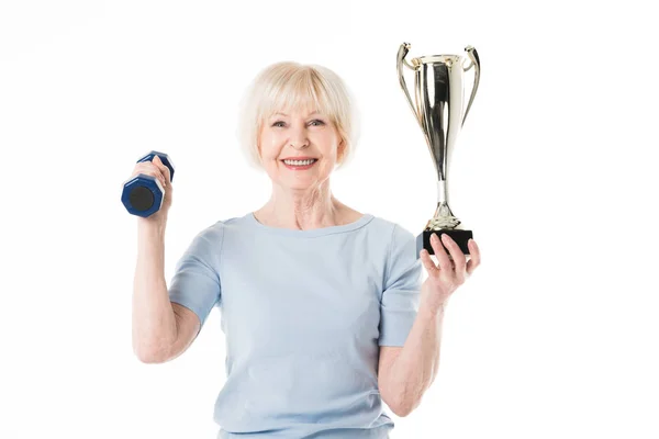 Senior sportswoman with trophy and dumbbell isolated on white — Stock Photo