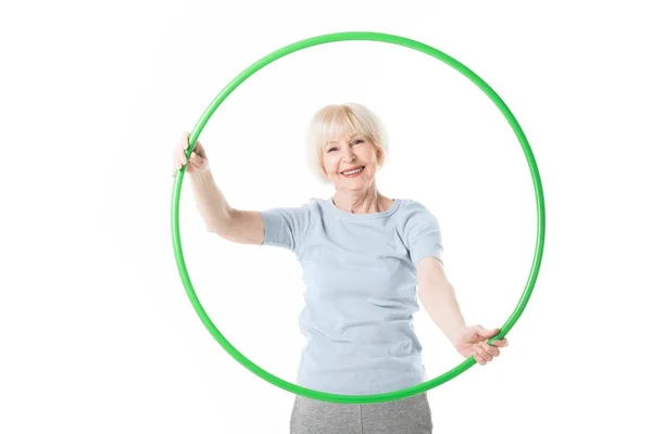 Retrato de deportista senior sosteniendo hula hoop aislado en blanco - foto de stock