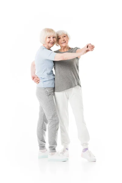 Two senior sportswomen doing exercise isolated on white — Stock Photo
