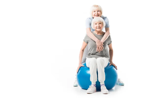Sportives seniors souriantes avec ballon de fitness isolé sur blanc — Photo de stock