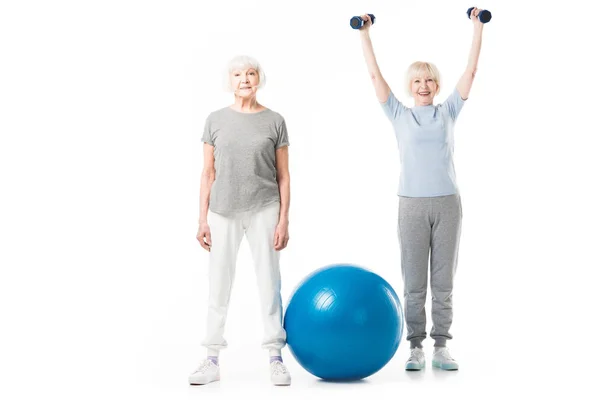 Sportives seniors avec ballon de fitness et haltères isolés sur blanc — Photo de stock