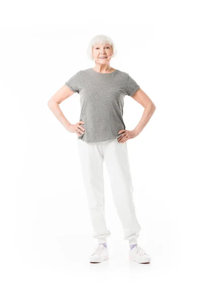 Sportiva anziana in piedi con le mani sulla vita isolata su bianco — Foto stock