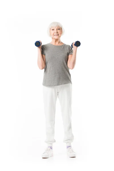 Seniorin macht Übung mit Hanteln isoliert auf weiß — Stockfoto