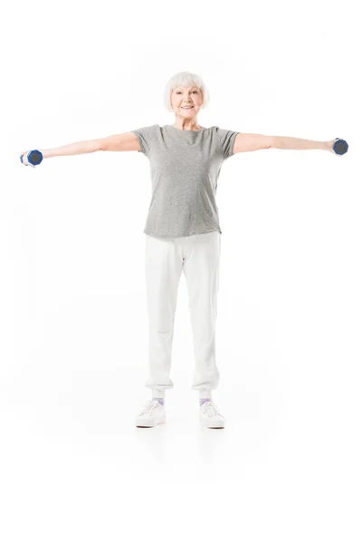 Senior sportswoman doing excercise with dumbbells isolated on white — Stock Photo