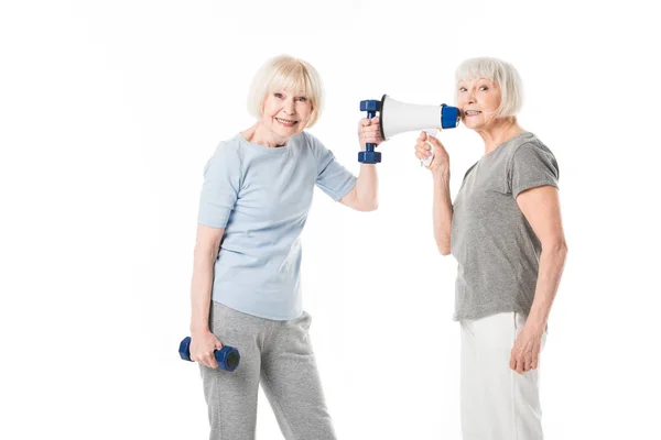 Two senior sportswomen with dumbbells and megaphone isolated on white — Stock Photo