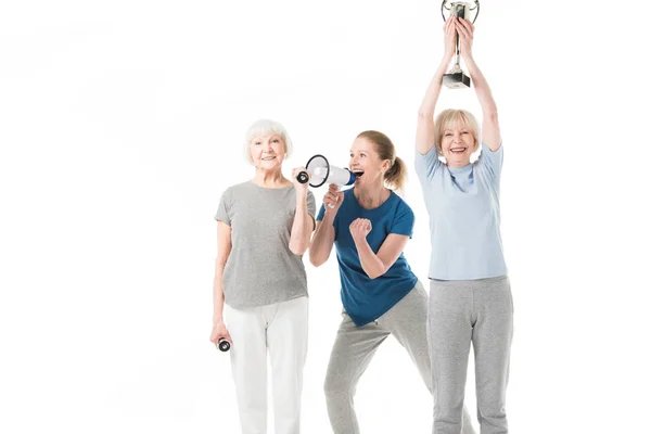 Coach and smiling sportswomen with dumbbells and trophy isolated on white — Stock Photo