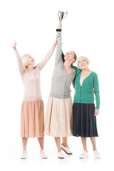 Mujeres elegantes celebrando con copa de trofeo aislado en blanco - foto de stock